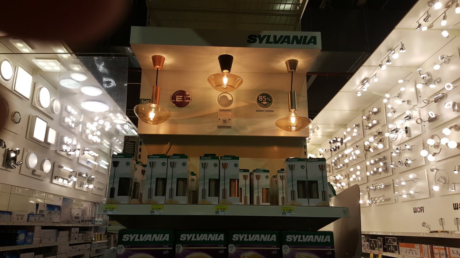 Sylvania-display met drie brandende hanglampen en dozen lampen in de verlichtingsafdeling van een doe-het-zelfzaak