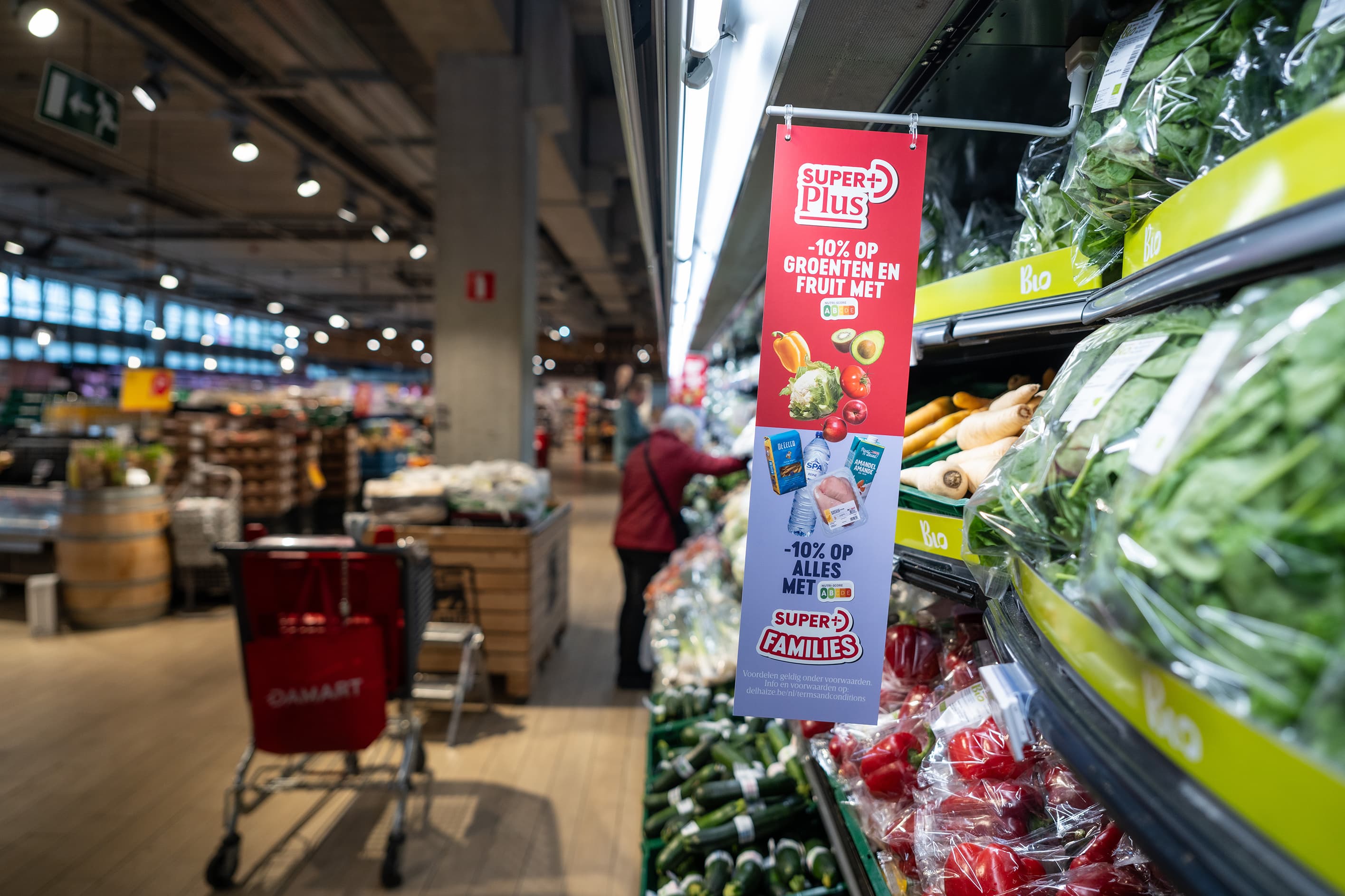 Hangende banner Super Plus «-10% op groenten en fruit» in het biogroenterek van een supermarkt